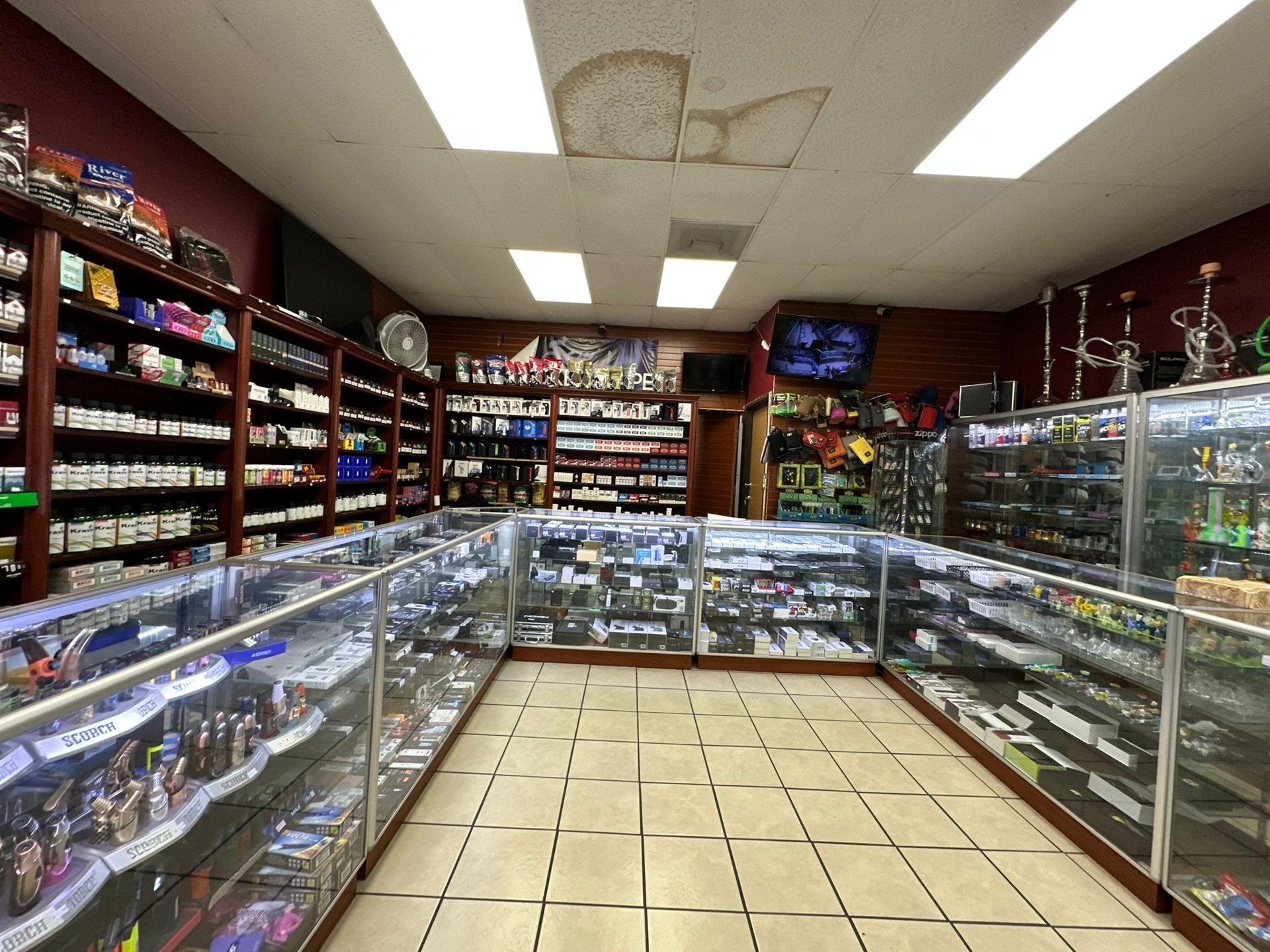 Display wall at Sam's Smoke & Vape stocked with vapes and smoking accessories