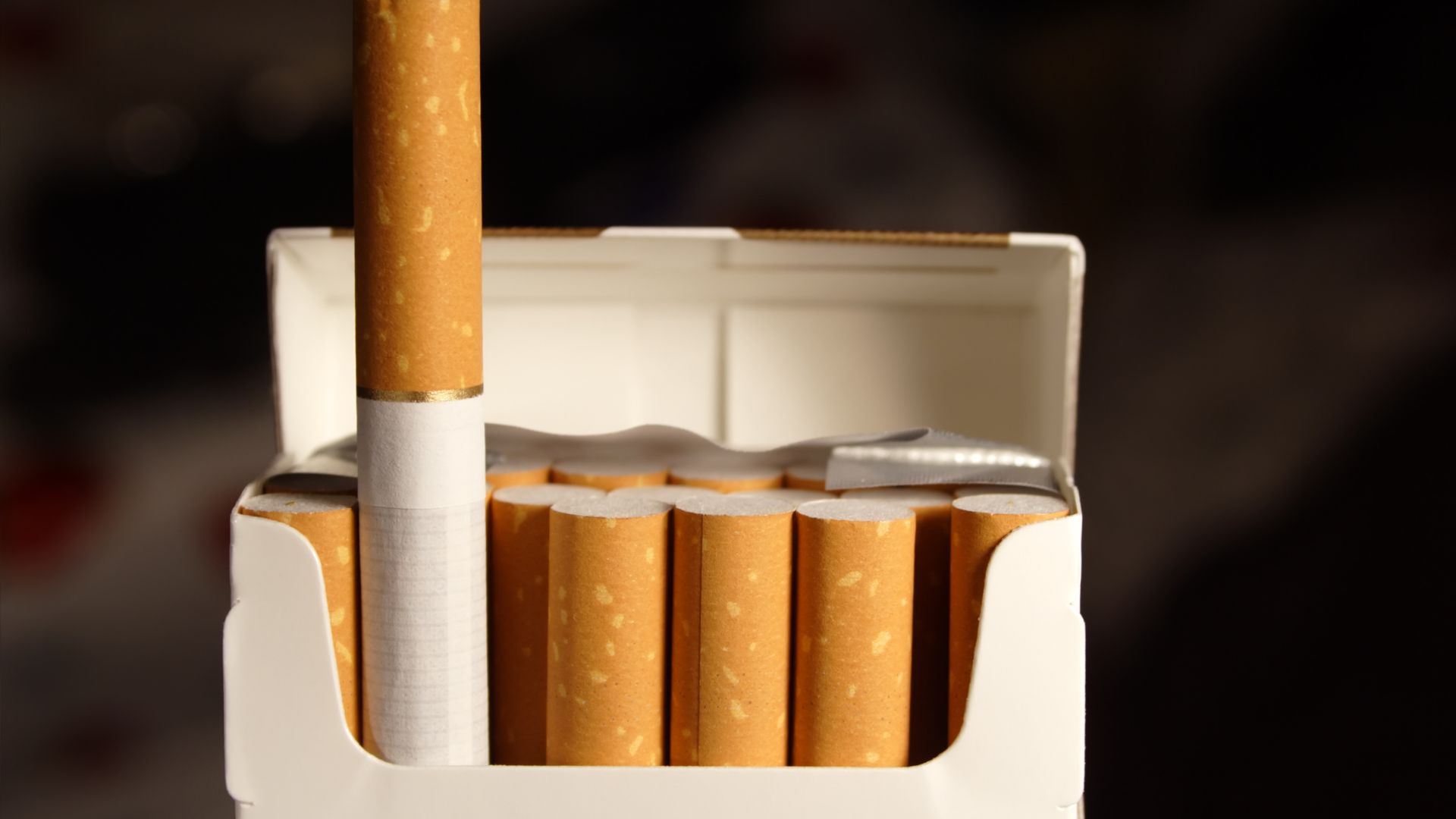 Open pack of cigarettes with one cigarette standing upright
