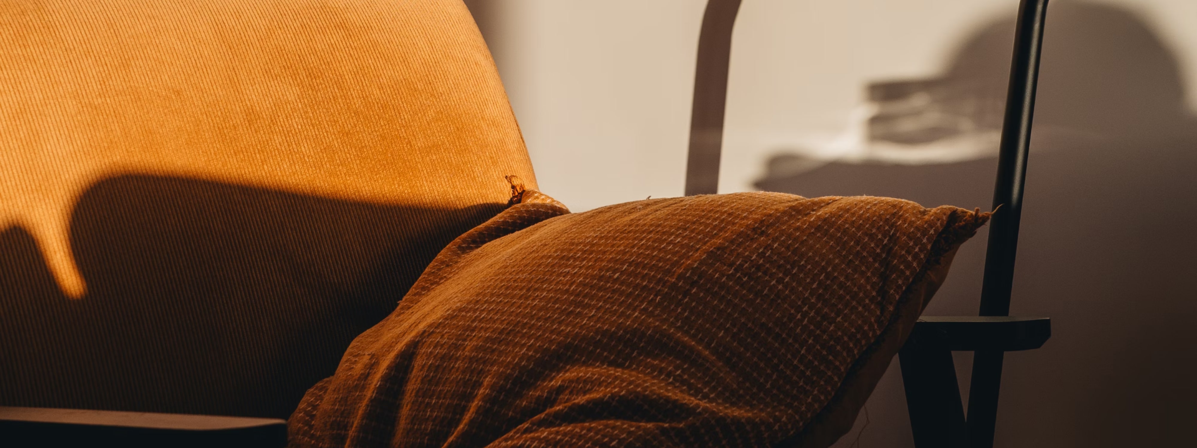 Warm golden-brown textured cushion on a chair with soft shadows