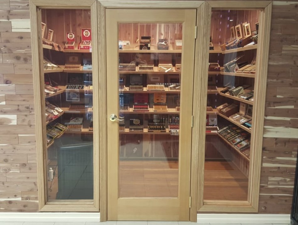 Glass-doored cabinet filled with various cigars and cigar boxes