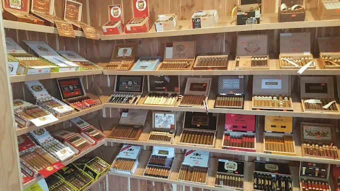 Wooden shelves displaying a variety of cigar boxes in different colors and sizes